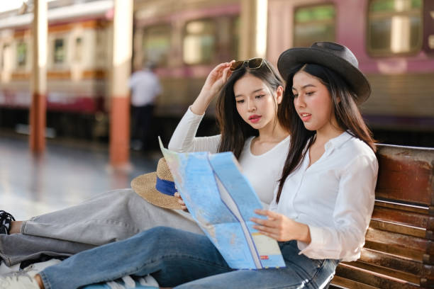 istock Two women sitting on a bench looking at a map 2166633218
