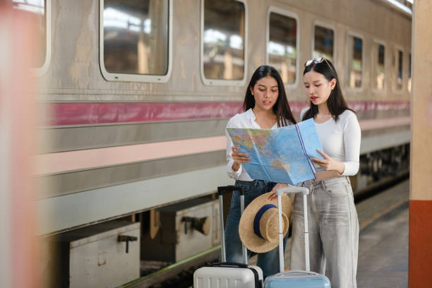 istock Two women are looking at a map while holding suitcases 2166633221