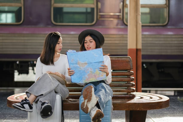 Two women sitting on a bench looking at a map