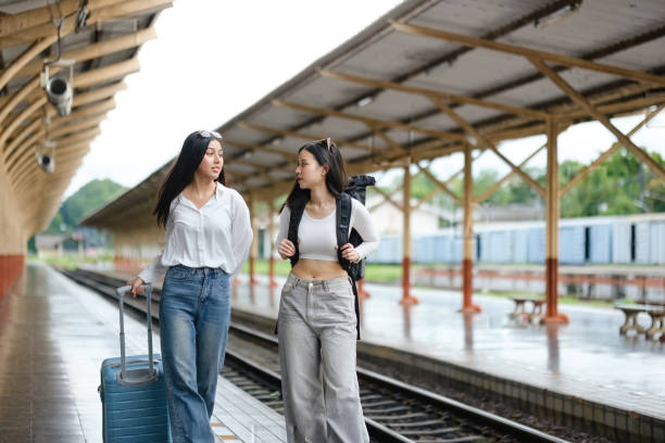 istock Two women are walking on a train platform with their luggage 2166633328
