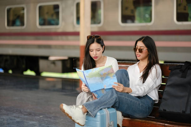 istock Two women sitting on a bench looking at a map 2166633510