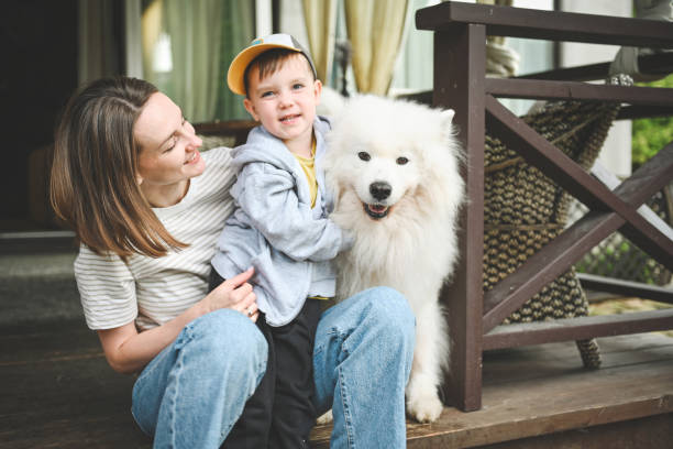istock mother and little son play with a dog 2166634538