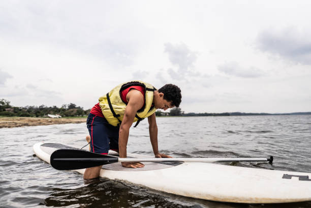 istock Young man paddleboarding in a lake 2166639966