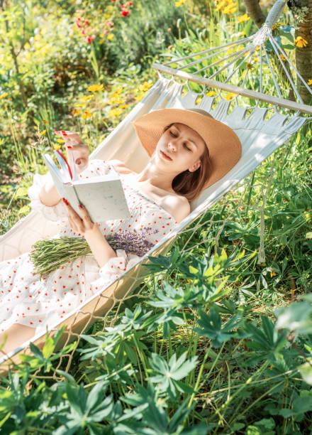 istock Young woman relaxing in a hammock outdoors in back yard 2166643648