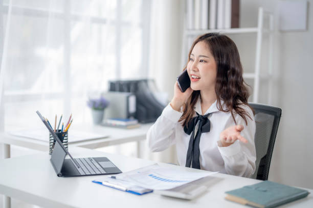 istock A woman is talking on her cell phone in a professional setting 2166643939