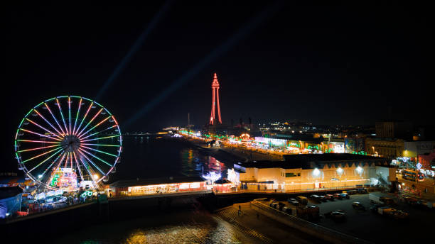 istock Nighttime cityscape with illuminated Ferris wheel and tower, festive lights 2166644675