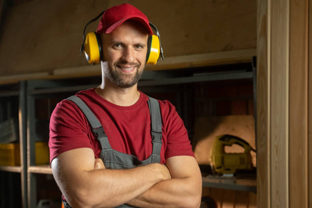 A skilled tradesman prepares for a construction task by donning protective glasses for safety. He demonstrates the importance of safeguarding his eyesight while working on various projects in the workshop