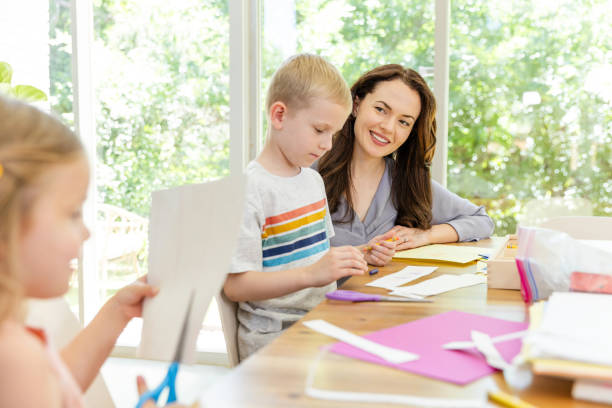 istock While helping son, homeschooling mom watches daughter use sharp scissors 2166648289