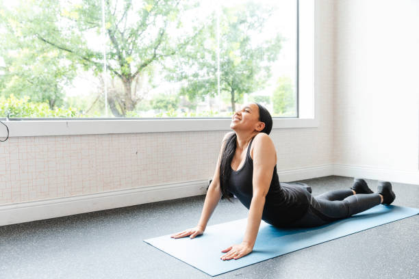 istock Woman in yoga studio practicing upward facing dog pose 2166649781