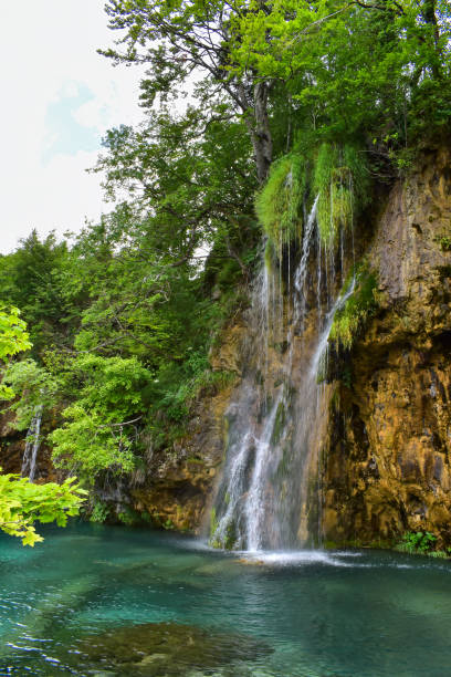 istock Waterfall drops in scenic lake 2166653498