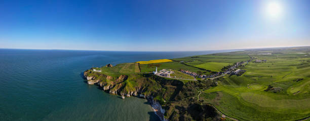 istock Panoramic view of a coastal landscape with cliffs, green fields, and a clear blue sky in Flamborough, England 2166653811