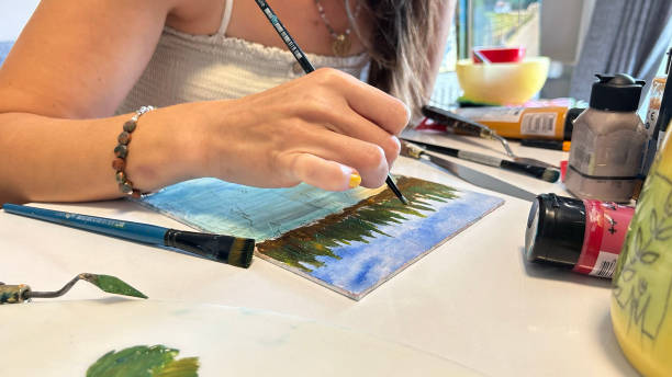 istock A close-up of a female painter working on a canvas with paints and brushes 2166654191