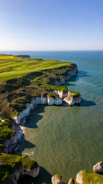 istock Aerial view of a rugged coastline with cliffs and a green golf course overlooking a serene blue sea in Flamborough, England 2166656766