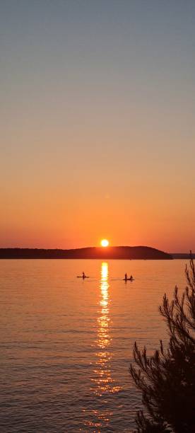 istock Strangers Waves on Paddleboards Beneath an Orange Adriatic Sunset 2166656997