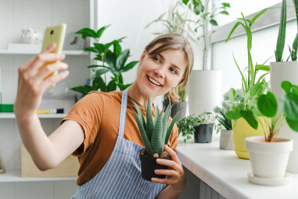 istock Woman taking selfie with plants using smartphone at home 2166657997