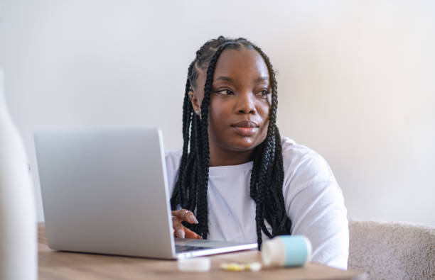 istock Happy black businesswoman using laptop typing and working online while sitting at workplace in office, copy space 2166659395