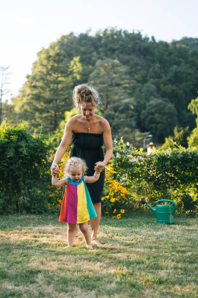 istock Mother and baby girl play in back yard 2166663607