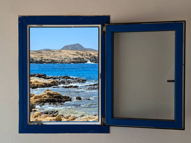 Rectangular steel window on a ship overlooking the open sea and sky.