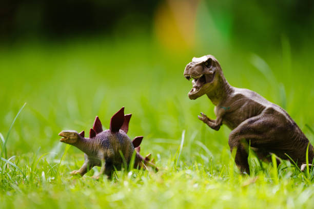 istock Child playing with dinosaur toy in sunny garden 2166668497