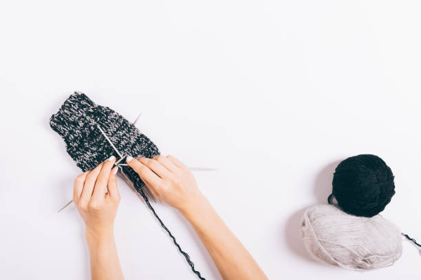 istock A person is knitting a hat with a black and white pattern 2166669473