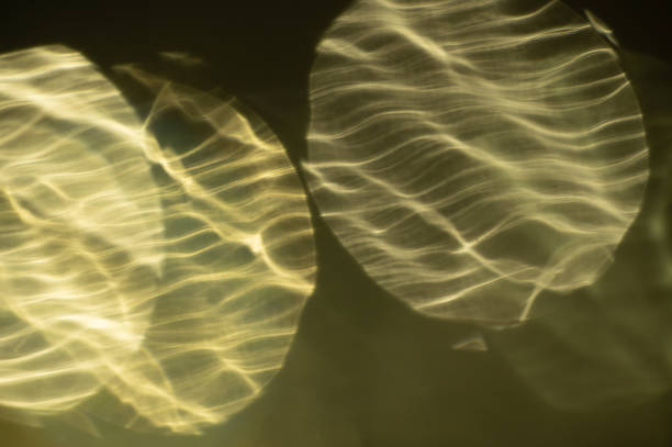 Abstract yellow colored sparkling blurred intersecting bokeh lights on a black background
