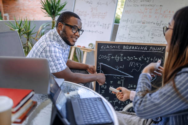 istock University students studying together at home on balcony having discussion in front of black board 2166672986