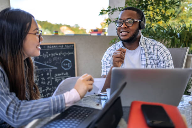 istock University students studying together at home on balcony having video call on laptop 2166673045