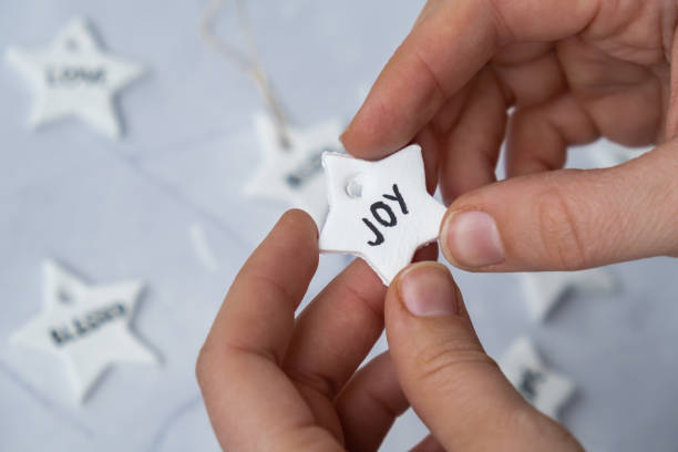 istock Christmas star with word JOY Creator is using white air dry clay for making decor to Christmas tree holiday. Creating hobby recreation activity that involves fingers. DIY crafting 2166673098