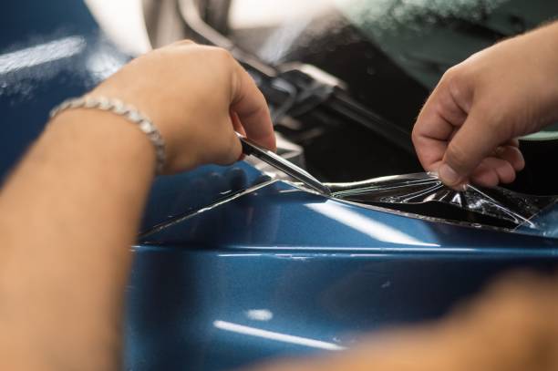 The master in the car service cuts the protective cutter.