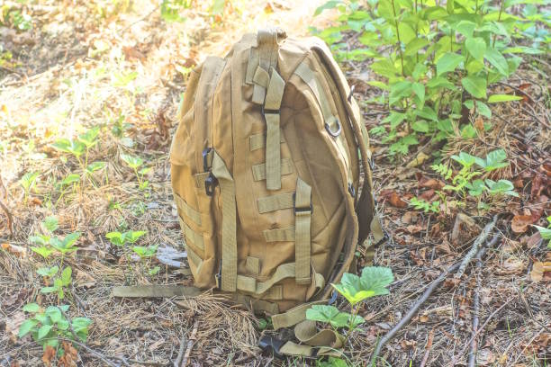 istock one brown army backpack stands on gray sand 2166674065