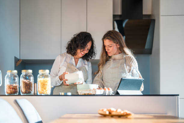 istock Hispanic Mother and Daughter Cooking in Modern Kitchen 2166677342