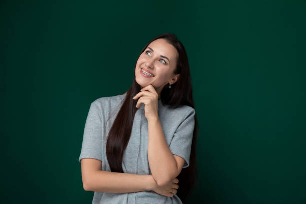 istock Woman Standing in Front of Green Wall 2166677413