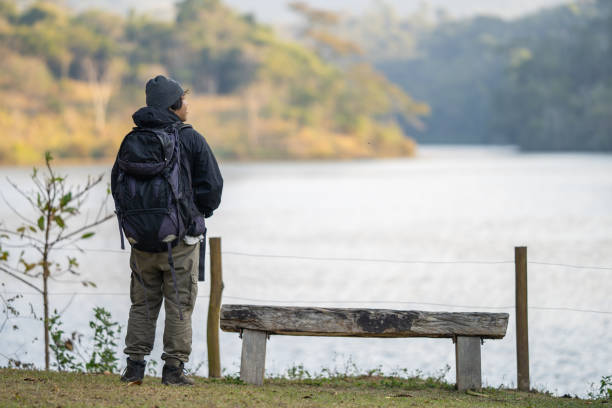 istock Back view of backpacker in natural landscape 2166677417