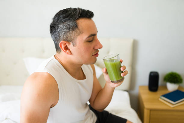 istock Hispanic man enjoys a refreshing green smoothie in a relaxed morning setting on his bed 2166678303