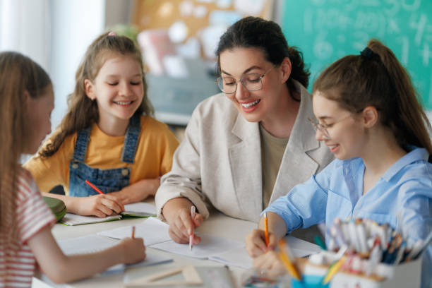 istock Happy kids and teacher at school 2166693556