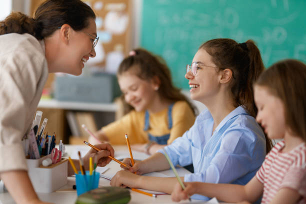 istock Happy kids and teacher at school 2166693557