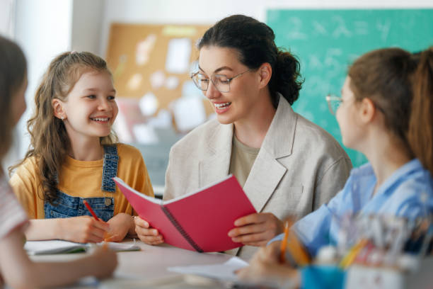 istock Happy kids and teacher at school 2166693559