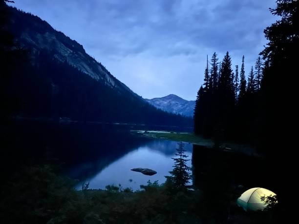 Alpine Lake at Night with a Lit Green Tent