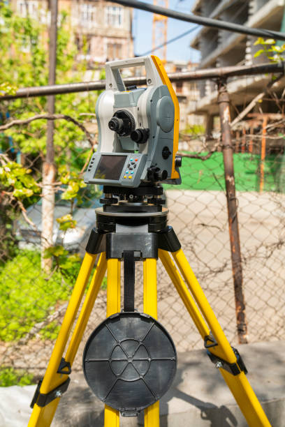 Close up of surveying instrument - total station on a tripod isolated on white background..