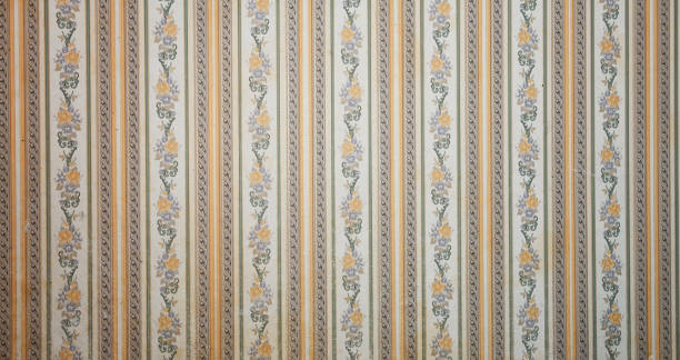 Old wallpaper on the wall. Old wallpaper for texture or background.