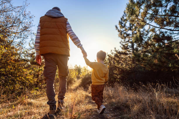 istock Dad and son enjoying an autumn walk in nature 2166705176