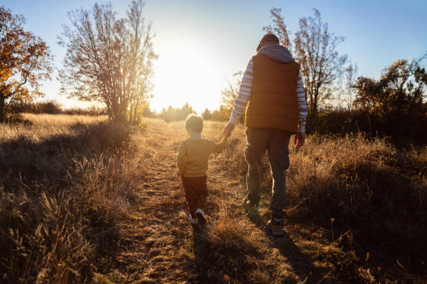 istock Dad and son enjoying an autumn walk in nature 2166705217