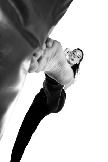 Woman kicking a heavy bag.