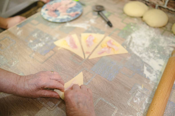 Active senior woman making some ham and cheese croissants for her family