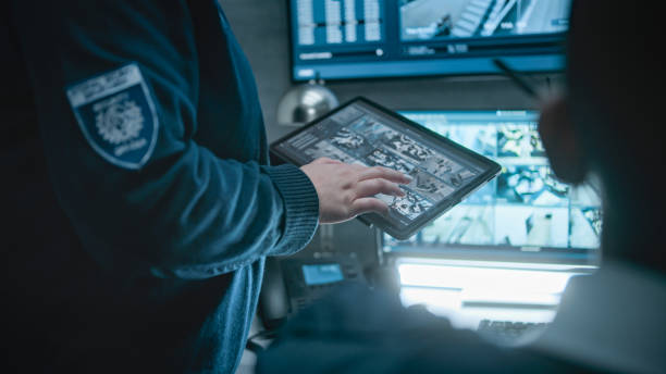 istock Female security officer talks with coworker, uses tablet computer 2166714389