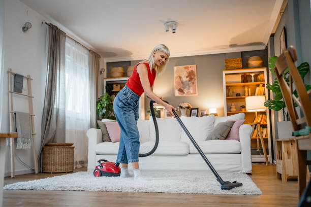 istock Young woman vacuuming her house 2166714433