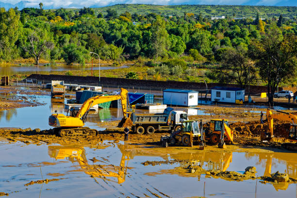 Excavator pushing stuck truck on construction site