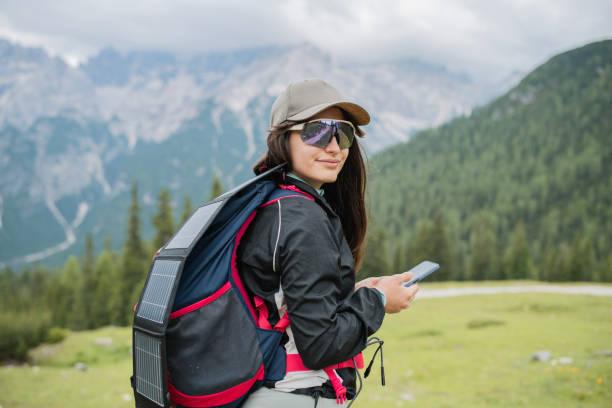 istock Woman on a hike is using portable solar panel system to charge her phone. 2166716797