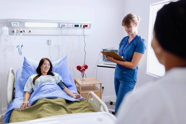 istock Nurse writing down statistics while measuring blood pressure of her patient 2166718415