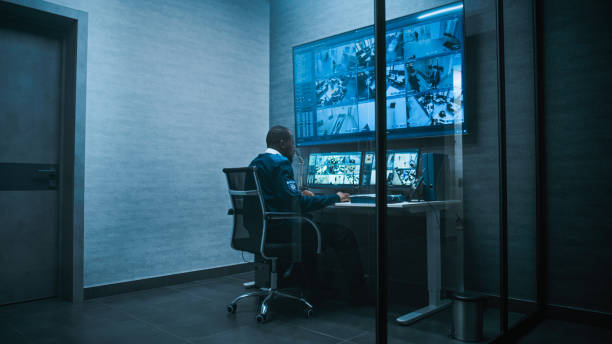 istock Security worker monitors CCTV cameras on multiple monitors and big digital screen 2166719336